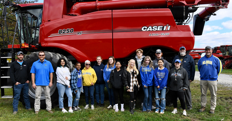 Students in the course called Understanding Today’s Agriculture stand in front of a combine that costs $750,000. With the students are Charlie Erwin, Dave Wharry of Hoobers, Inc., and Mark Isaacs far right. The field trip is one of four offered during the course.