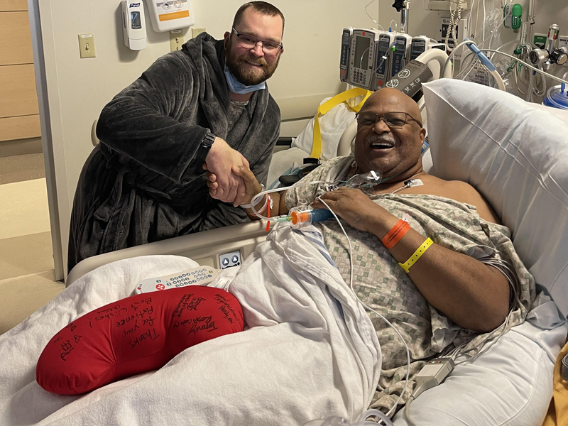 Bill Sumiel (right) and Tim Letts smile following Sumiel’s kidney transplant surgery at Christiana Hospital in December of 2021. Photo from a hospital room. Bill Sumiel (right) and Tim Letts smile following Sumiel’s kidney transplant surgery at Christiana Hospital in December of 2021. Letts donated a kidney to Sumiel after the two met in Letts’ car while he was driving for Uber.