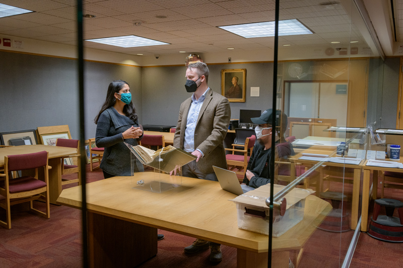 CAS-HIST-UDARI-Race_Inequality_in_Delaware-121421 Examining source materials in Special Collections at Morris Library for the “Race and Inequality in Delaware” class are (from left) Anisha Gupta, a doctoral student in preservation studies; Prof. Dael Norwood; and Tyler Welsh, a senior majoring in history education.