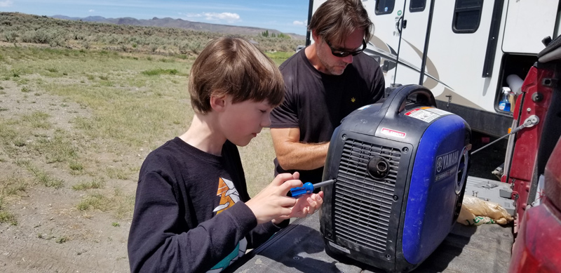 The generators powering the Willard family’s recreational trailer during their cross-country travels required emergency maintenance, which made for some stressful situations. But fixing these problems together turned every potential crisis into a “very proud moment,” said Glynn Willard, pictured here with his oldest son, Gavyn. 