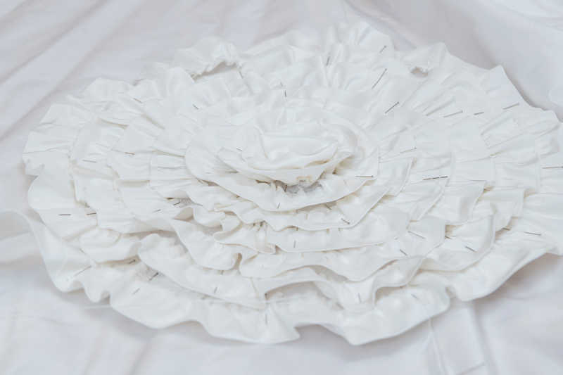 A close-up of a handmade rosette, a hallmark of designer Ann Lowe’s style. Seven rosettes will embellish the skirt of the finished gown. A close-up of a handmade rosette, a hallmark of designer Ann Lowe’s style. Seven rosettes will embellish the skirt of the finished gown.