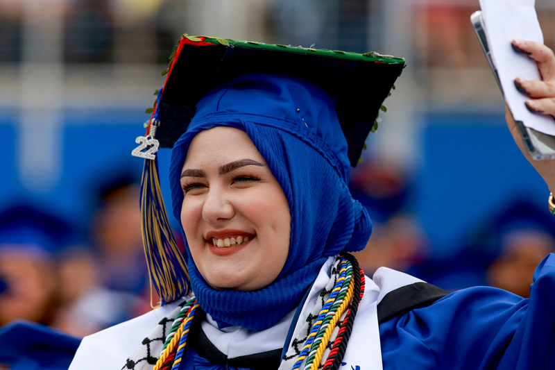 Nada Abuasi waves to friends and family at the College of Arts and Sciences Convocation on May 27.