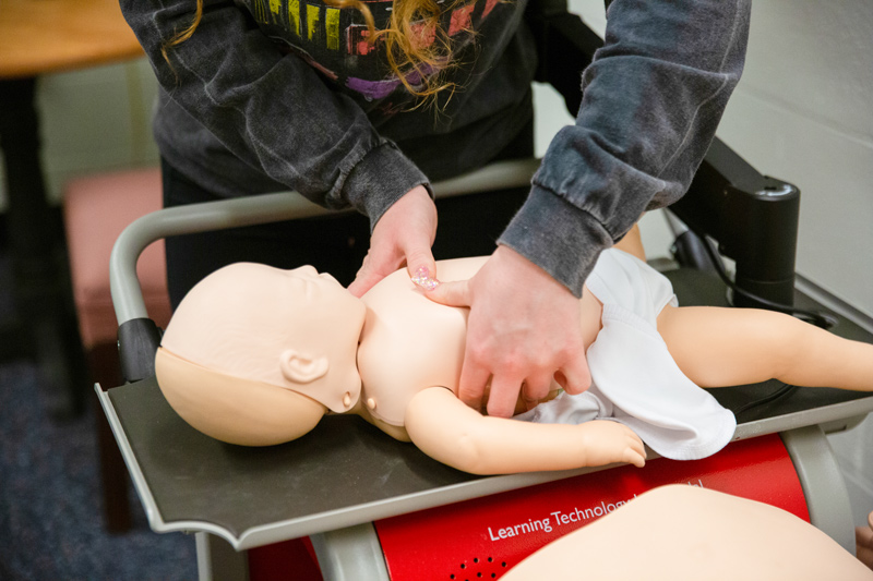Nursing major Mackenzie Seyka must also prove she knows how to perform CPR on an infant to pass her quarterly skills test. Here, she uses less force and just two fingers to perform chest compressions on a baby mannequin.  