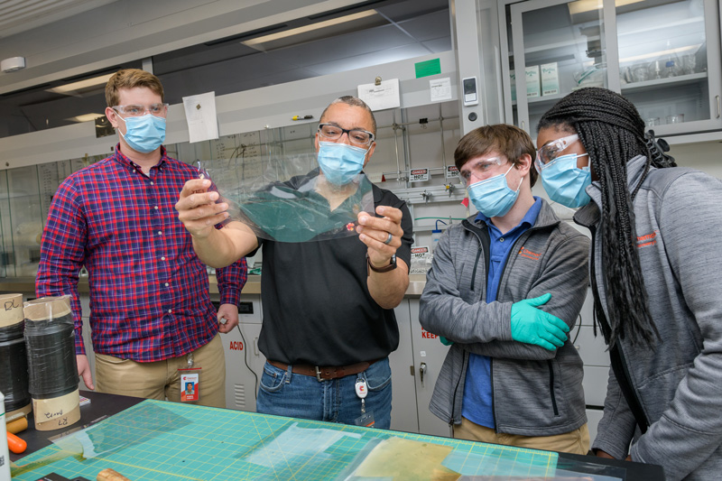 Gerry Brown (second from the left), an R&D Technical Fellow, holds a Chemours fuel cell membrane as fellow Blue Hens and Chemours R&D engineers Robbie Loesch (left), Joey Pritchard (second from right) and Brittany Georges (right) look on. Gerry Brown (second from the left), an R&D Technical Fellow, holds a Chemours fuel cell membrane as fellow Blue Hens and Chemours R&D engineers Robbie Loesch (left), Joey Pritchard (second from right) and Brittany Georges (right) look on.