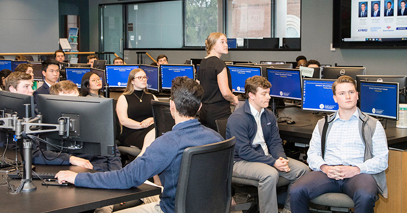 The Blue Hen Investment Club meets in the Michael and Rosann Geltzeiler Trading Center in Purnell Hall to discuss their investment strategy.