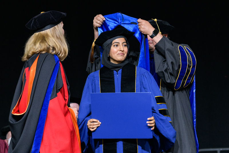 Iflah Laraib (center) receives her doctoral hood from adviser Anderson Janotti, associate professor of materials science and engineering, during UD’s Doctoral Hooding Ceremony Thursday. At left is Jill Higginson, associate dean of the College of Engineering.
