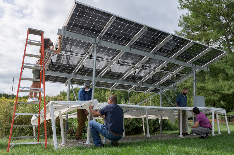 A new solar array that incorporates bifacial solar modules (those that absorb the sun’s energy from the top side and the bottom side) was installed outside the Institute of Energy Conversion in 2021, offering new research capacity to students and other researchers. Among those working on the array in this shot are (left to right): undergraduate Ryan Purnell (on the ladder), Kunal Vohra, a recent UD graduate student, IEC research technician Shannon Field, Professor Steven Hegedus, leader of the project, and doctoral student Sergio Sepúlveda.