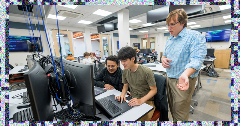 Andrew Novocin (far right), associate professor in the UD Department of Electrical and Computer Engineering, works with cybersecurity students during a Cyber Scholars event in mid-October.