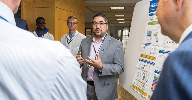 Associate professor Mark Blenner (center) discusses his lab’s work on plastic biotransformation with UD President Dennis Assanis and Gov. John Carney. 