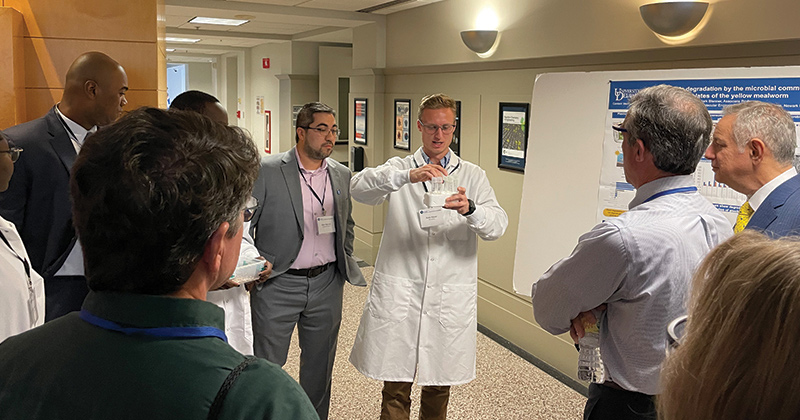 Doctoral student Ross Klauer (center) shows Gov. Carney the mealworms being studied in the labs of Prof. Mark Blenner and Prof. Kevin Solomon for their plastic degradation capabilities.