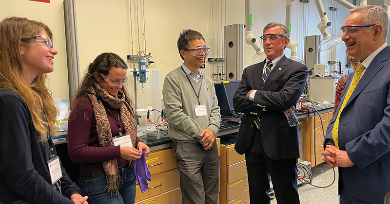 While touring the UD lab of Henry Belin Du Pont Chair Yushan Yan (center), UD President Dennis Assanis (far right) and Gov. John Carney (second from right) also spoke with doctoral student Alexandra Oliveira (second from left) and senior Rebecca Beswick (far left). 