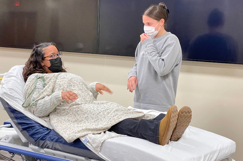 Allie Melchione (right), now a senior nursing major, obtained her Birth Companion Program Certificate in the spring of 2021. Here, she’s paired with fellow nursing major Johnna Garber, practicing calming techniques. 