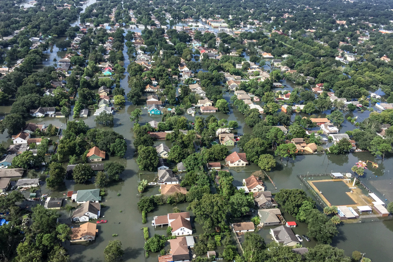 A photograph from a helicopter shows the flooding in a community. Researchers at the Disaster Research Center at the University of Delaware and colleagues are exploring the tensions between coastal resilience to hazards and economic prosperity and equity. The goal is to create tools to better understand how people and agencies interact during disasters, in order to help coastal communities remain resilient today and as our climate changes.