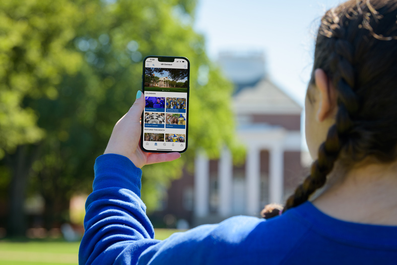 Student holds her phone, displaying the new UD Connect app “We are excited to add this new digital platform to enhance the UD campus experience,” said José-Luis Riera, UD vice president for student life.