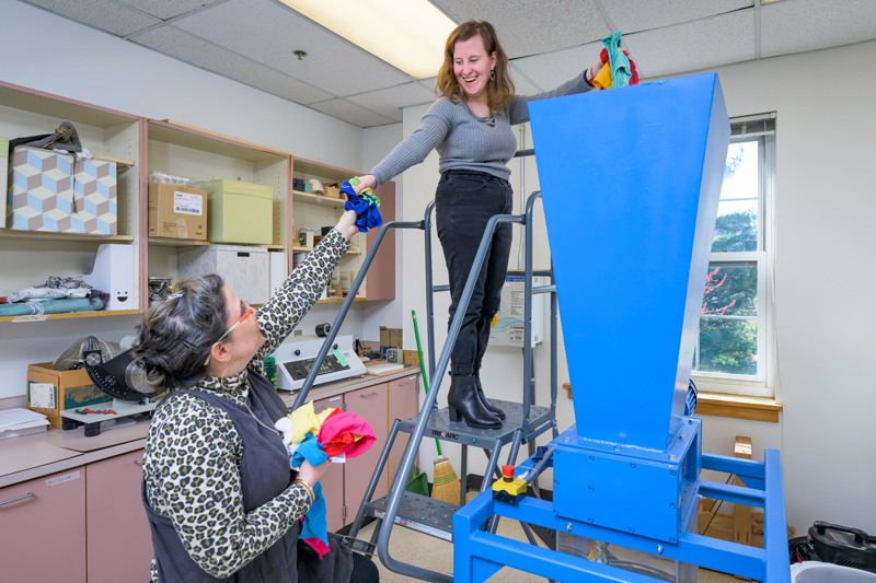 UD Associate Professor Kelly Cobb and Michelle Yatvitskiy, a graduate student pursuing a master’s degree in fashion studies, feed recycled textiles into a shredding machine. UD Associate Professor Kelly Cobb and Michelle Yatvitskiy, a graduate student pursuing a master’s degree in fashion studies, feed recycled textiles into a shredding machine.