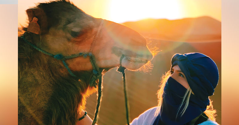 student with camel in the Sahara 
