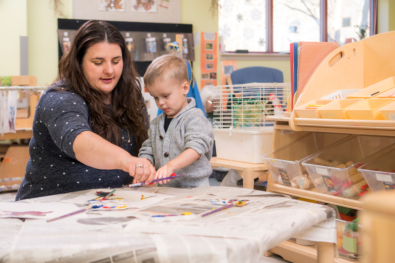 Anamarie Whitaker, assistant professor in the College of Education and Human Development’s Department of Human Development and Family Sciences, paints with a child in CEHD’s Lab School.