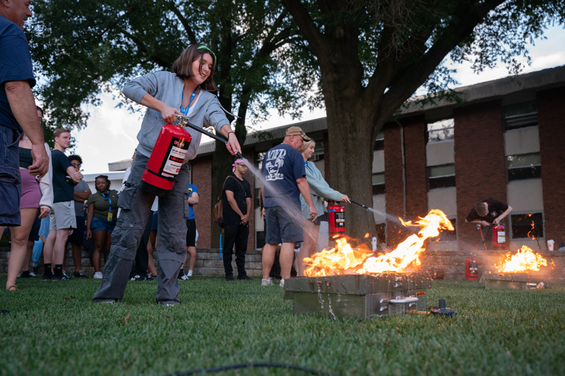 The University of Delaware Safety Training Night included a fire extinguisher training, which taught resident assistants to use the P.A.S.S. method (pull, aim, squeeze and sweep) with water extinguishers to douse some types of fires.
