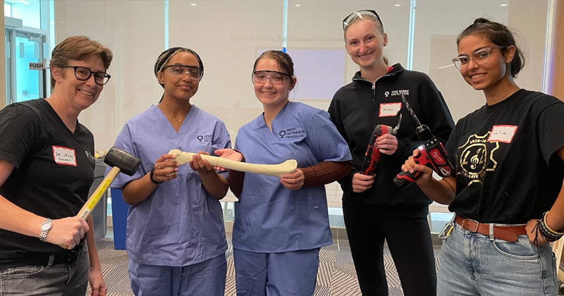 Participants in a Perry Initiative program show off their surgical repairs, aided by Buckley (far left) and mechanical engineering students Karen Scharpf (second from right) and Julia Jacob (far right). 