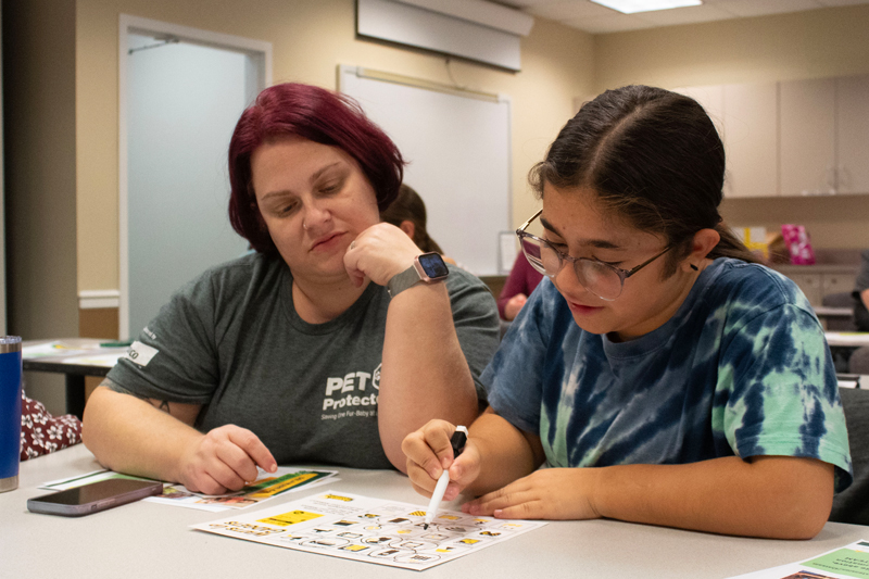 Mom and daughter Heather Cuz and Alexa use art supplies to build their prototype of a renewable energy source.