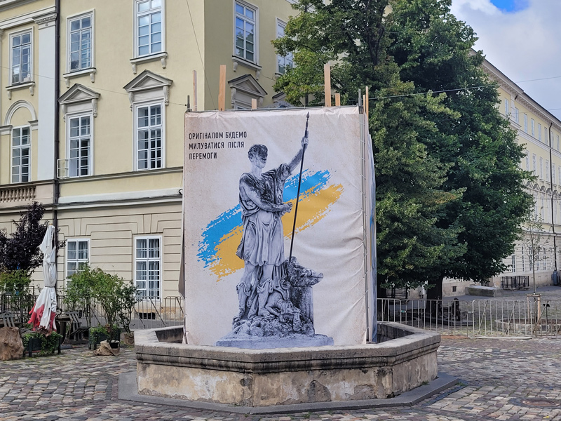 “We will enjoy the original after our victory,” reads a sign, protecting a monument in Lviv, Ukraine.