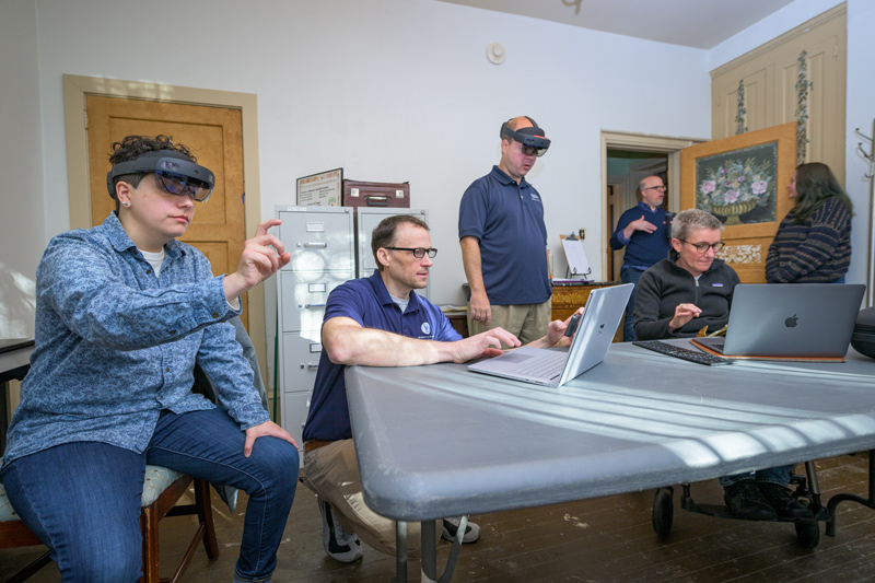 Setting up the technology for a test at Rockwood Museum are UD team members (foreground, from left) Margalit Schindler, Tim Leefeldt, Eric Cantrell and Joelle Wickens; behind them (from left) museum director Ryan Grover speaks with Morrigan Kelley.
