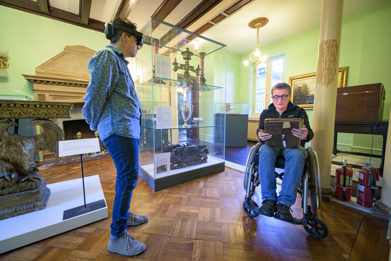 Margalit Schindler (left), wearing the HoloLens 2 augmented reality headset, speaks with Joelle Wickens about the technology and its usefulness in the Rockwood Museum project to develop a conservation plan for the historic building and its collections. 