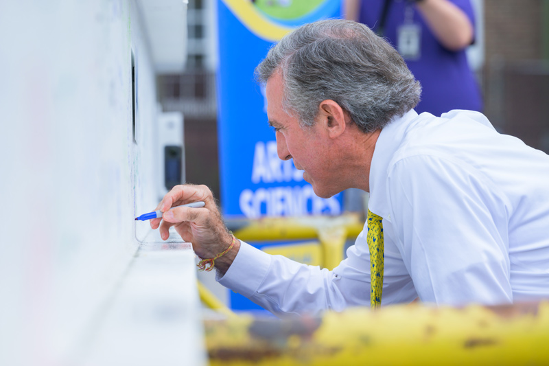 Delaware Gov. John C. Carney Jr. adds his name to the last structural beam during the “topping out” event at Building X.
