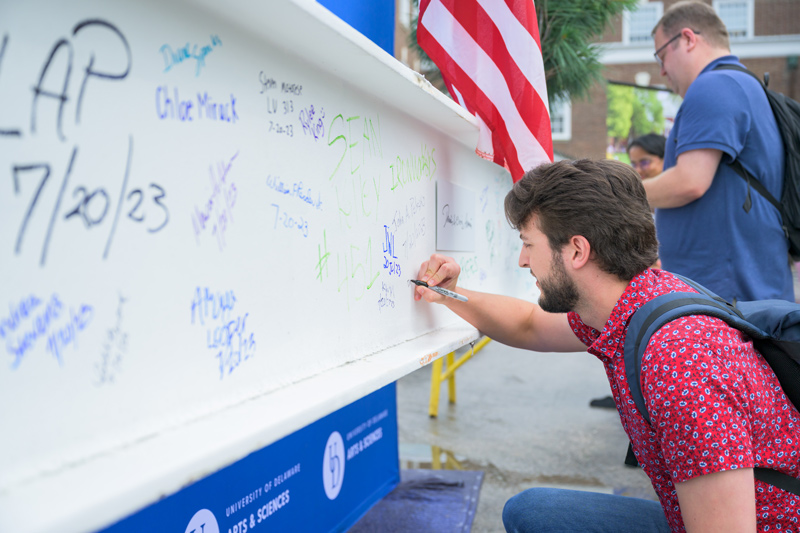 All were welcome to sign their names to the final beam before it was moved to its lofty spot on Building X, a major new laboratory space at the University of Delaware. Tradesmen, contractors, researchers, administrators, elected officials, students and staff put their marks on the 2,000-pound beam.