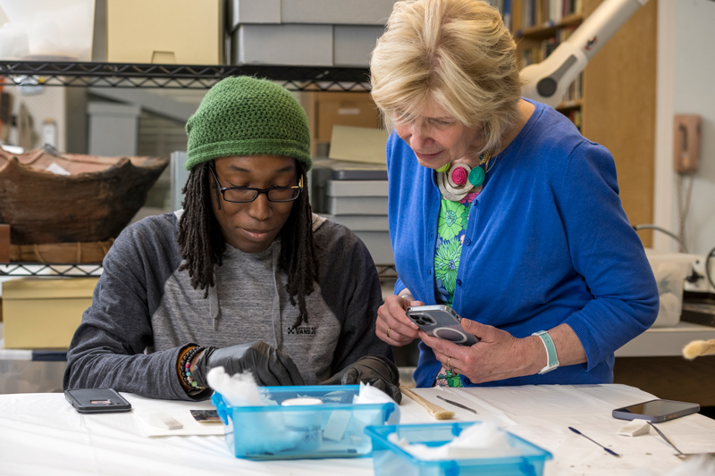 Student David Rand (left) works to repair a photo with program leader Debra Hess Norris looking on. Student David Rand (left) works to repair a photo with program leader Debra Hess Norris looking on.