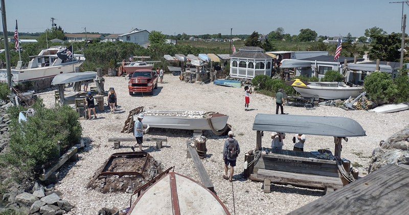 The Coastal Resilience Design Studio summer team for 2022 wander around Paskey's Wharf, discussing the town's fishing history and culture with local community members.