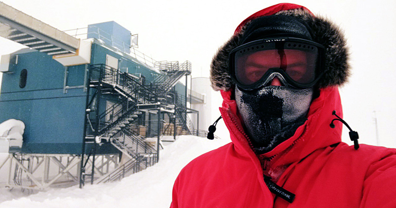 Spencer Axani, UD assistant professor of physics and astronomy, at the South Pole, with the IceCube Laboratory in the background. It holds the servers that collect data from IceCube’s sensors under the ice.  