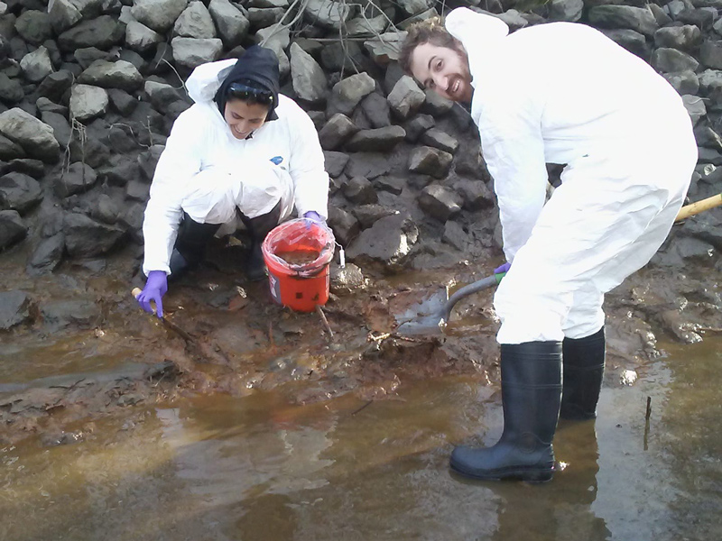 Izaditame (left) collected soil and river sediment samples from an industrial site on the banks of the Christina River adjacent to an EPA Superfund site. Arsenic, a highly mobile heavy metal often found in abundance at sites such as this, poses a threat to the safety of water systems and is of increasing importance in the face of sea level rise predictions. Izaditame (left) collected soil and river sediment samples from an industrial site on the banks of the Christina River adjacent to an EPA Superfund site. Arsenic, a highly mobile heavy metal often found in abundance at sites such as this, poses a threat to the safety of water systems and is of increasing importance in the face of sea level rise predictions.