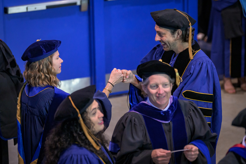 Angelia Seyfferth (left), professor of biogeochemistry and plant-soil interaction, shares a fancy fist bump with new doctoral graduate Sean Fettrow.