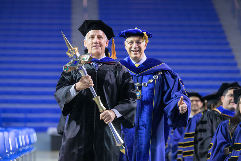 UD President Dennis Assanis gives a thumbs-up as the procession begins at the 2023 Doctoral Hooding Ceremony Thursday morning. Louis F. Rossi, dean of UD’s Graduate College and vice provost for Graduate and Professional Education , is leading the way with the mace. The Hooding Ceremony recognizes students who have achieved the highest academic degree — the doctorate.