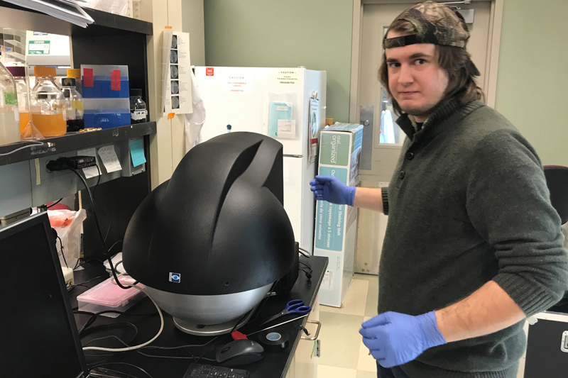 Former UD graduate student Nick Johnson operates the multi-spectral imaging instrument to look at plant sentinel response.