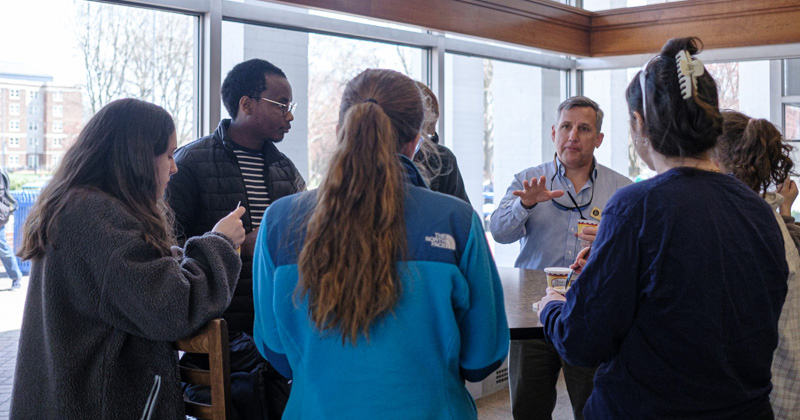 Lou Rossi, UD Graduate College dean and vice provost of graduate and professional education, enjoys a cup of his favorite UDairy Creamery Delaware River Mud Pie ice cream while chatting with graduate students.