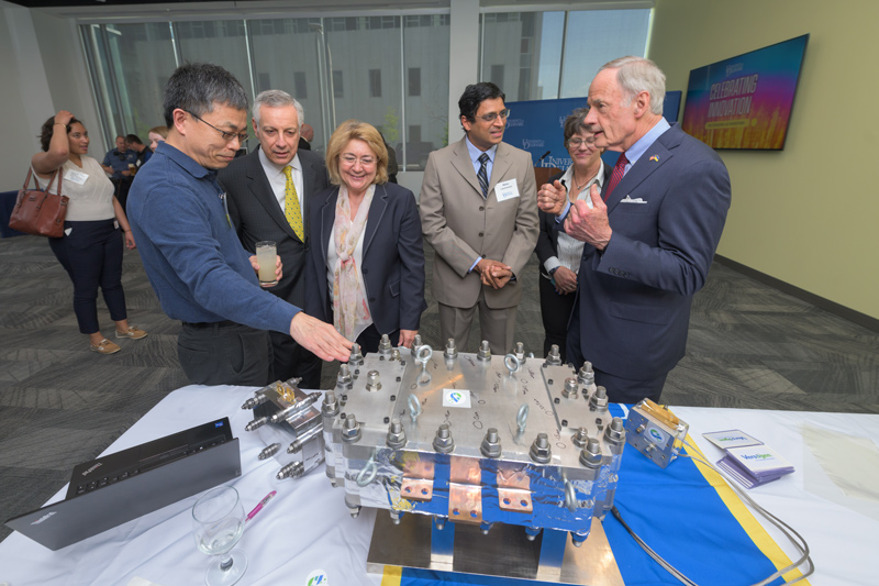 Professor Yushan Yan (left) provides an overview of the clean hydrogen electrolyzer technology discovered at UD and scaled up at Versogen, his startup company, to UD President Dennis Assanis, First Lady Eleni Assanis and U.S. Sen. Tom Carper. Versogen Chief Technology Officer Balsu Lakshmanan and Director of Membrane Production Sharon Perl are shown in the background. Professor Yushan Yan (left) provides an overview of the clean hydrogen electrolyzer technology discovered at UD and scaled up at Versogen, his startup company, to UD President Dennis Assanis, First Lady Eleni Assanis and U.S. Sen. Tom Carper. Versogen Chief Technology Officer Balsu Lakshmanan and Director of Membrane Production Sharon Perl are shown in the background.
