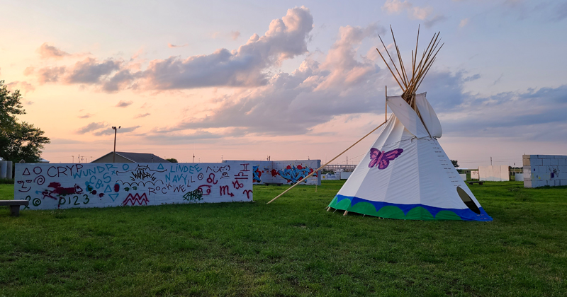 A tipi and painted walls in Waniyetu Wowapi Art Park, Eagle Butte, South Dakota