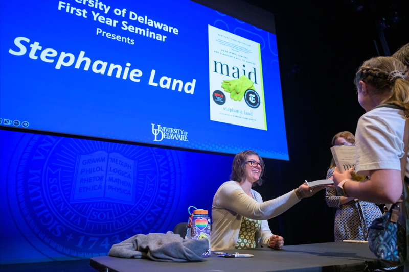 Stephanie Land signs copies of her book, “Maid: Hard Work, Low Pay, and a Mother’s Will to Survive.”