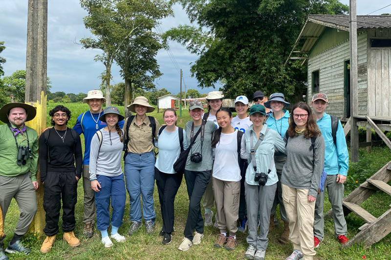 UD students and faculty posed for a group photo at an Amazonian village, where they were greeted by a local guide who described village life.