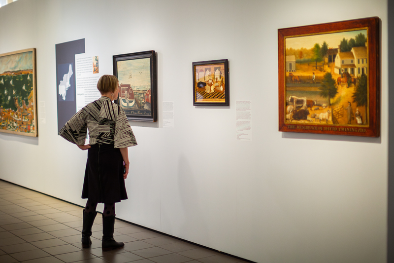 A visitor examines one of the paintings in the exhibit. 
