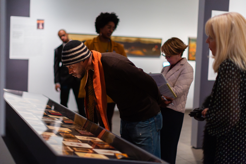 A visitor examines a selection of photos in the exhibit. 