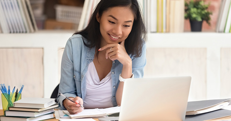Young girl sitting at desk looking at a computer.