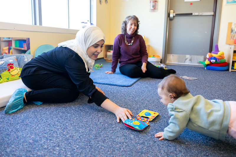 Michele Lobo, associate professor of physical therapy, and Bashayer Alharbi, a doctoral student in the biomechanics and movement science program, play with 6-month-old Emma as they work together to design and test PRECARE, a developmental surveillance tool that aims to detect developmental delays and support early intervention.