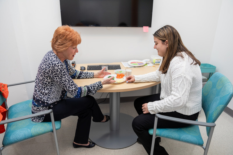 UD’s Nutrition Clinic is open to the public and sees 1,200 patients per year, including several with diabetes. The clinic also provides hands-on experiential learning to students like Madison Lucas (right), a first-year student in the 4+1 nutrition and dietetics program. Here, Lucas is working with registered dietitian and certified diabetes care and education specialist Melissa Stabler on portion sizes. UD’s Nutrition Clinic is open to the public and sees 1,200 patients per year, including several with diabetes. The clinic also provides hands-on experiential learning to students like Madison Lucas (right), a first-year student in the 4+1 nutrition and dietetics program. Here, Lucas is working with registered dietitian and certified diabetes care and education specialist Melissa Stabler on portion sizes.