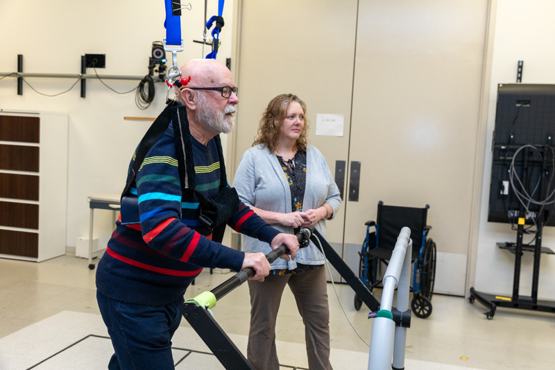 Susanne Morton, associate professor of physical therapy (right), was awarded $50,000 from the Maggie E. Neumann Health Sciences Research Fund to study walking patterns in people with mild cognitive impairment. Pictured here, Morton analyzes walking patterns and balance as study participant Jim Bowman walks on a split-belt treadmill, which engages two belts at varying speeds, forcing one leg to move twice as fast.