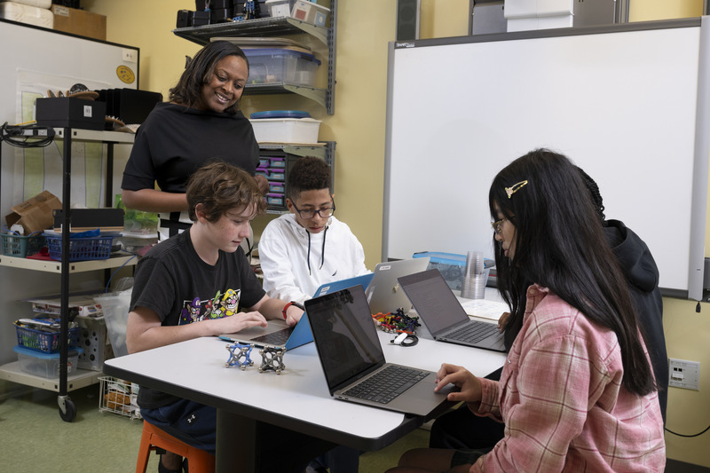 Mellissa Gordon, associate professor in the College of Education and Human Development (CEHD), works with middle school students on an online learning activity at CEHD’s The College School.