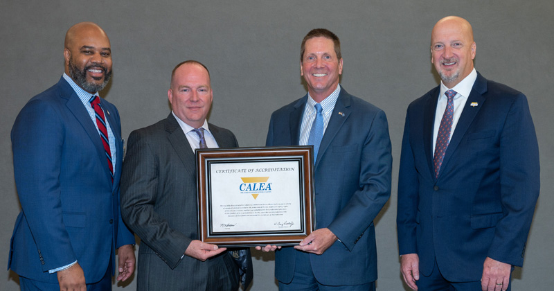University of Delaware Chief of Police Pat Ogden (third from left) receives the department’s re-accreditation certificate at CALEA’s annual conference in November 2024. Chief Ogden is seen with, from left, CALEA Commission chairman Marlon Lynch; UD Police Sergeant Jeff Gates; and CALEA executive director Craig Hartley. University of Delaware Chief of Police Pat Ogden (third from left) receives the department’s re-accreditation certificate at CALEA’s annual conference in November 2024. Chief Ogden is seen with, from left, CALEA Commission chairman Marlon Lynch; UD Police Sergeant Jeff Gates; and CALEA executive director Craig Hartley.