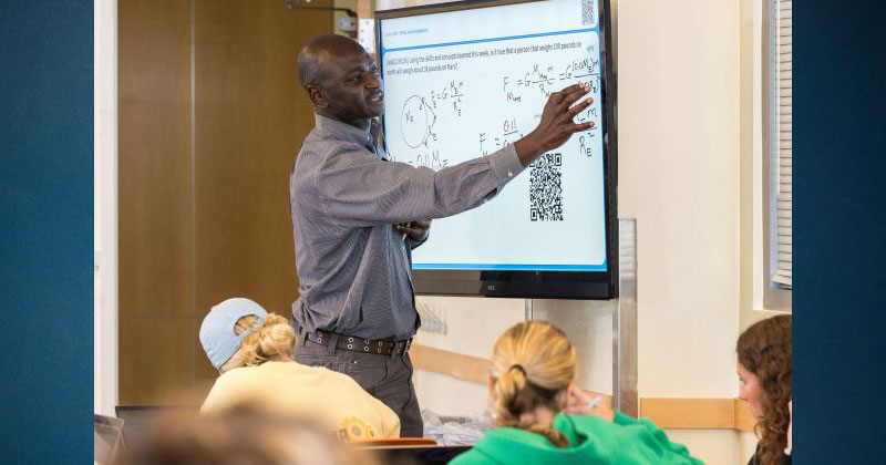 Winter Institute on Learning A professor facing a projector screen while teaching a class